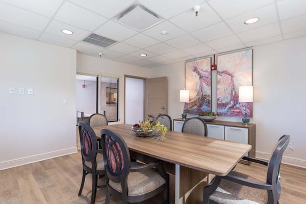 Bright dining room with a large table and artwork