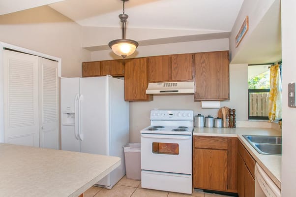 Bright kitchen with wooden cabinets and white appliances