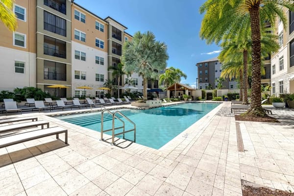 Swimming pool area with lounge chairs and palm trees