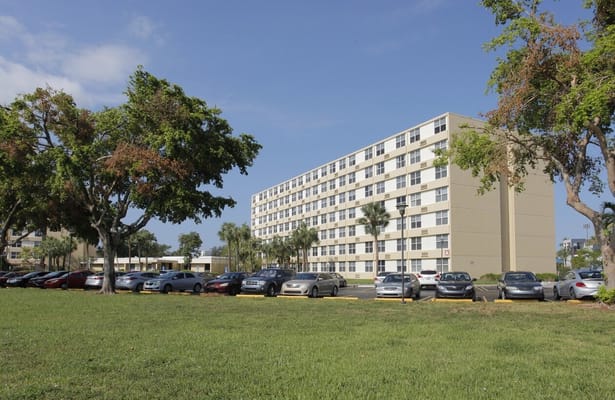 Parking lot in front of St. Andrews Towers with trees and a blue sky