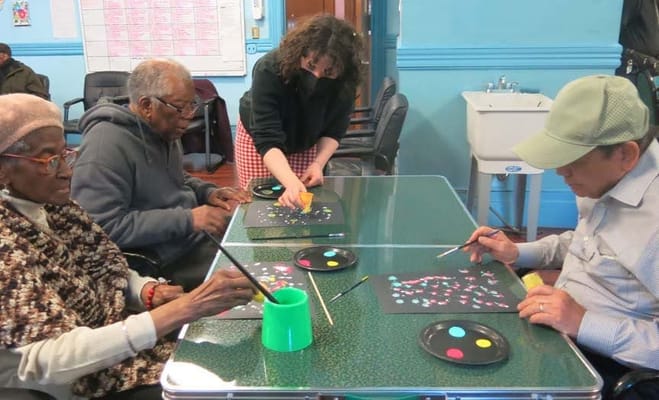 Residents participating in an art activity with staff assistance
