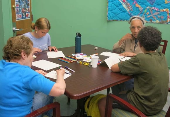 Residents and staff engaged in an art activity at a table