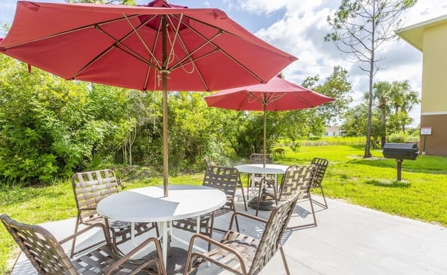 Outdoor seating area with shaded tables and chairs