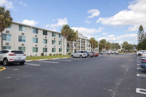 Exterior view of Christian Manor Apartments with parking area