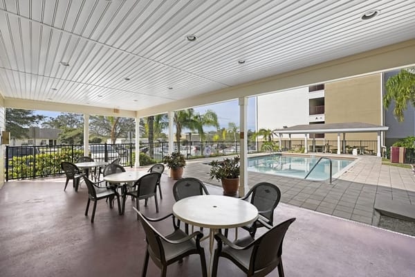 Outdoor seating area by the pool at a senior facility