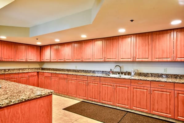 Brightly lit kitchen area with wooden cabinets