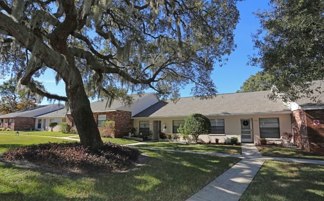 Exterior view of Forest Oaks Villas Apartments surrounded by trees