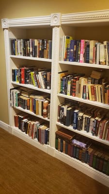Bookshelves filled with various books in a common area