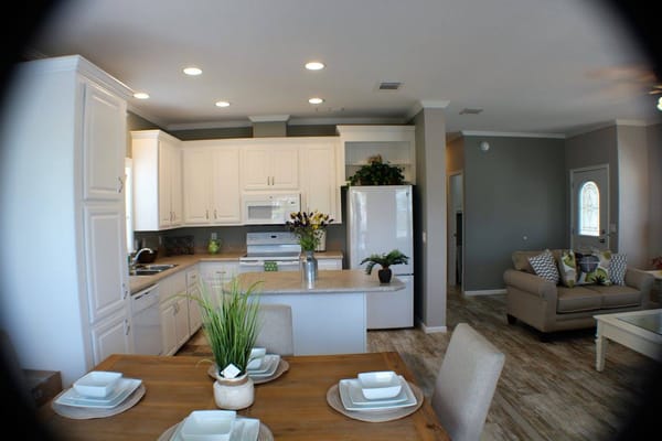 Modern kitchen with dining area in senior living facility