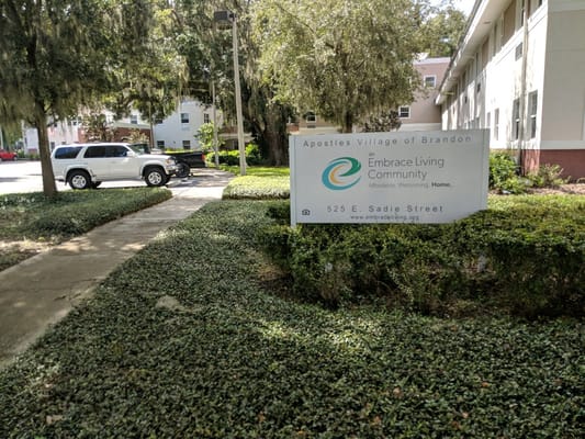 Sign for Apostles Village in an outdoor space