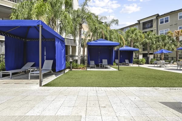 Outdoor lounge area with cabanas and lounge chairs