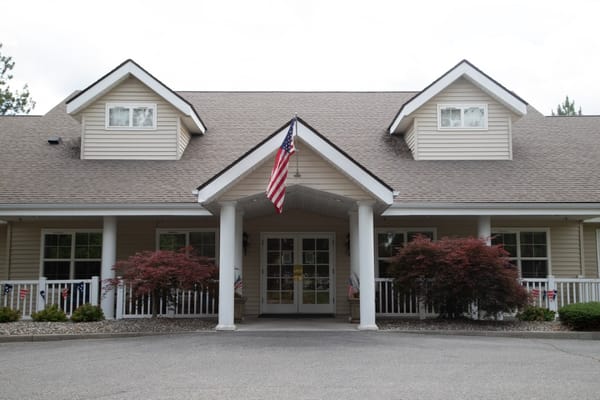 Front entrance of Avista Senior Living Spokane with American flag