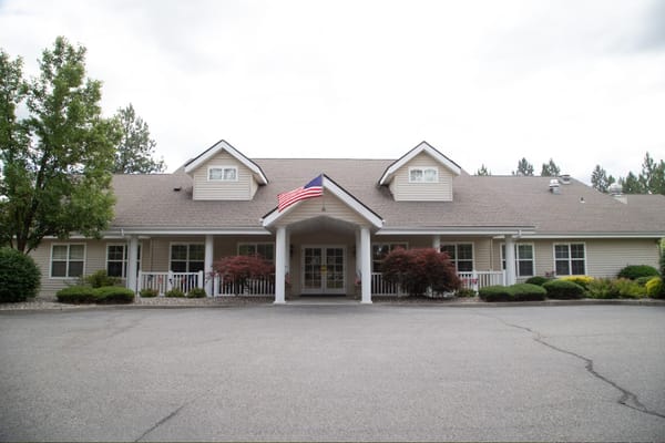 Exterior view of Avista Senior Living Spokane with an American flag