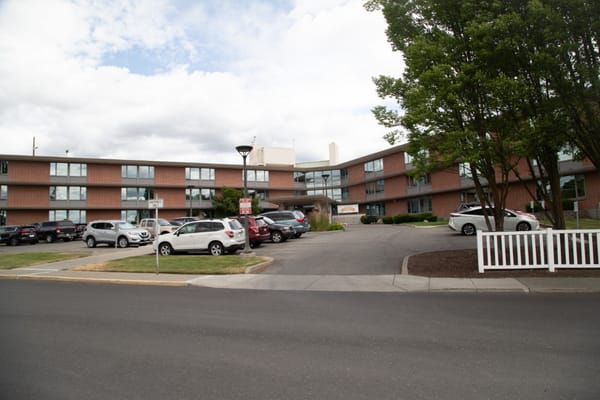 Front view of Riverview Retirement Community showing the building and parking area.