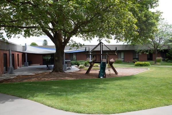 Playground area surrounded by greenery at Riverview Retirement Community