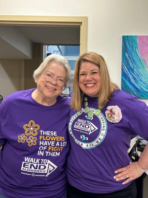 Staff and resident participating in a walk event for Alzheimer's awareness