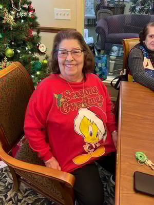 Resident wearing a festive sweater at a holiday gathering