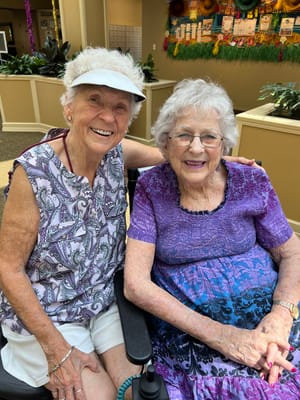 Two smiling residents in a common area