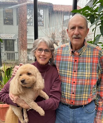 Residents posing with a dog in a bright indoor space