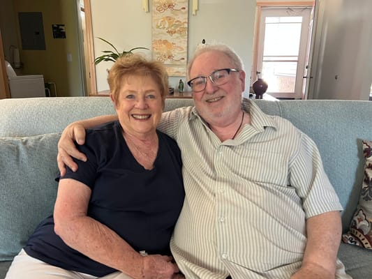 Two residents smiling together on a couch