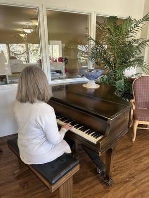 Resident playing piano in an activity room