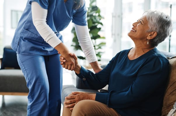 Staff assisting a senior resident in a common area