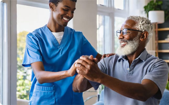 Caregiver assisting a senior man in a bright interior
