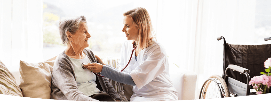 Nurse interacting with an elderly resident in a cozy living room