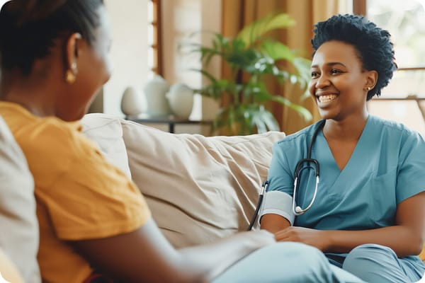 A caregiver sitting on a couch with a resident