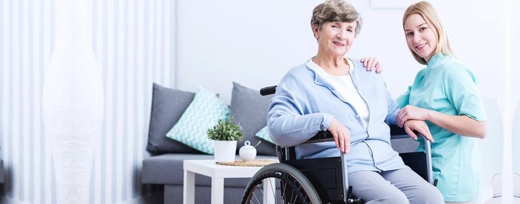 A caregiver assisting a resident in a wheelchair