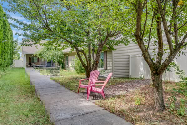 Outdoor space with pink chairs and trees