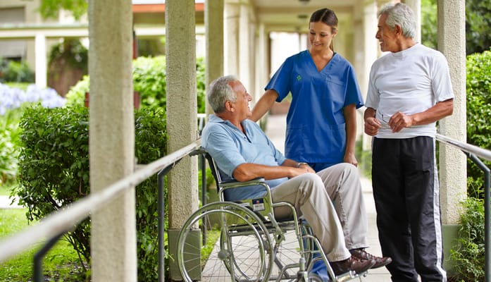A staff member chatting with residents in a garden area