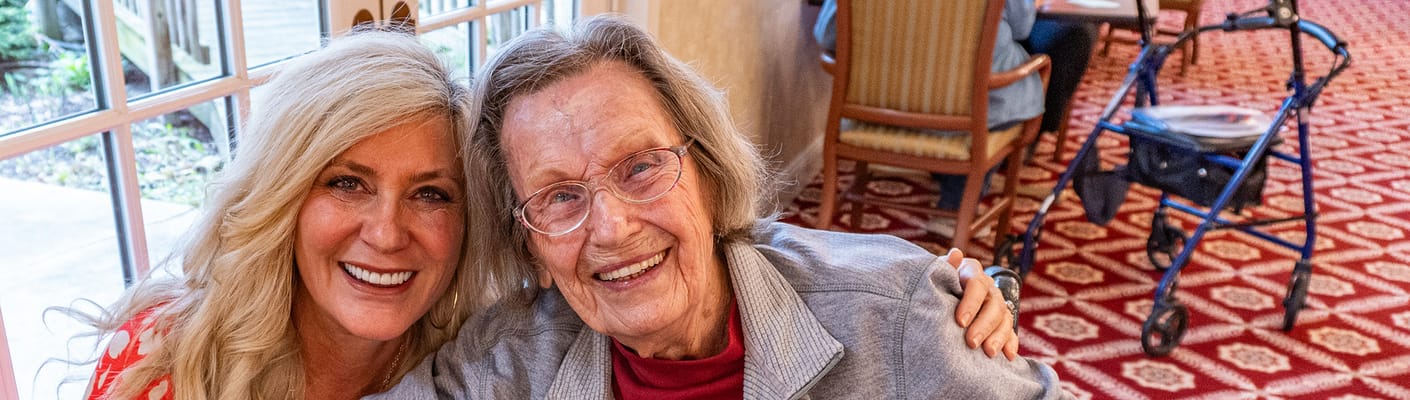 Resident and staff member smiling together