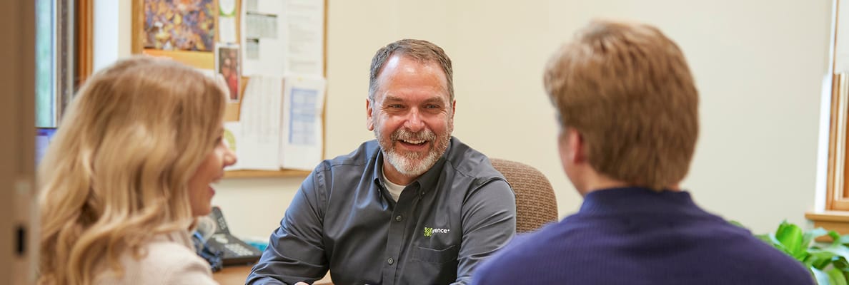 Staff member engaged in conversation with two residents