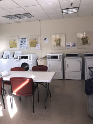 Laundry room with washing machines and seating area
