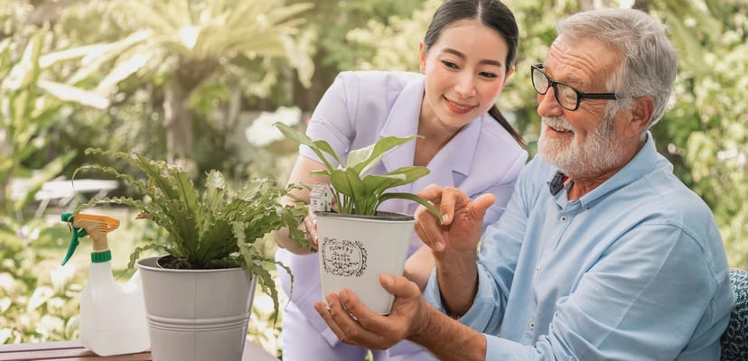 Senior resident and caregiver interacting with a plant