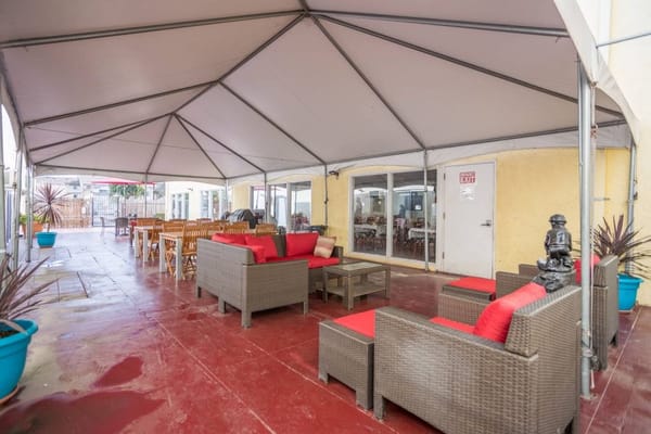 Covered outdoor seating area with red cushions