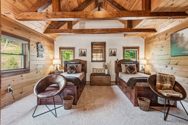A spacious bedroom with wooden decor and two beds