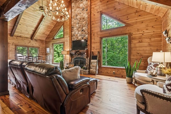 Lounge area featuring leather recliners, wooden accents, and large windows