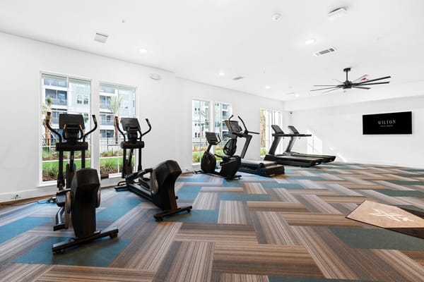 Fitness room with exercise equipment and large windows