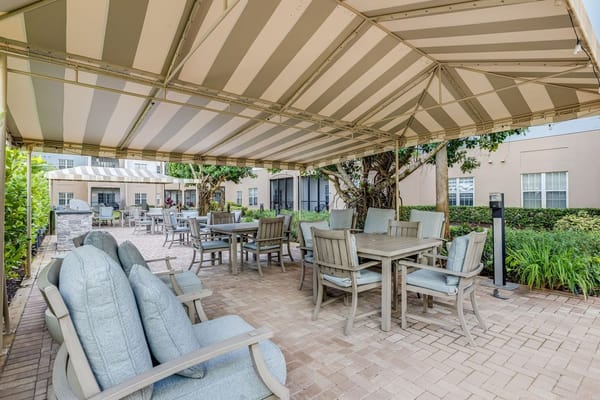 Cozy outdoor patio area with tables and seating under a striped canopy