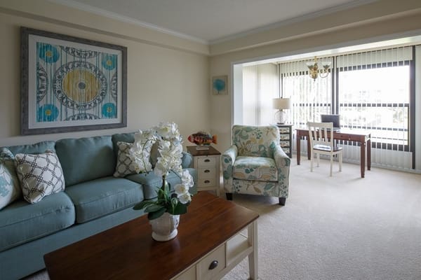 Bright and airy living room with a sofa, coffee table, and office space
