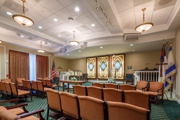 Interior view of the chapel with seating and stained glass windows.