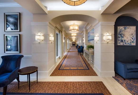 Spacious hallway with decorative lighting and seating areas