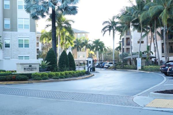 Entrance to Marquis Coral Springs with palm trees and gate