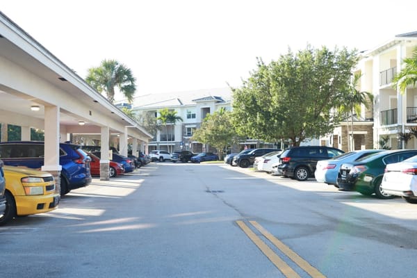 Parking area with vehicles and surrounding buildings