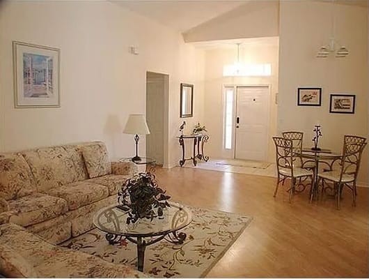 Spacious living room with floral couch and dining area