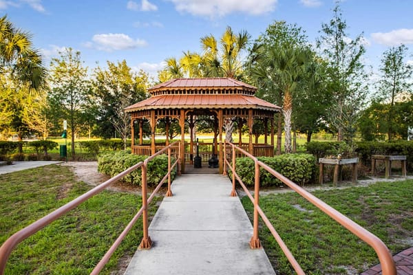 Wooden gazebo with a red roof surrounded by greenery