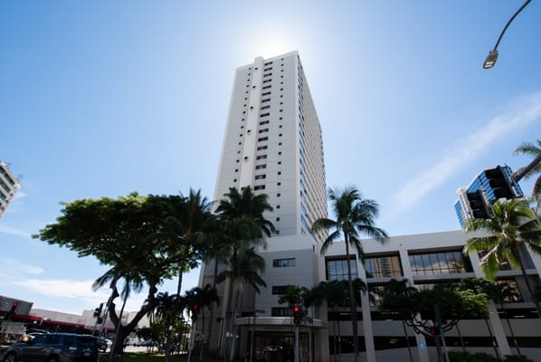 Exterior view of a tall building with palm trees