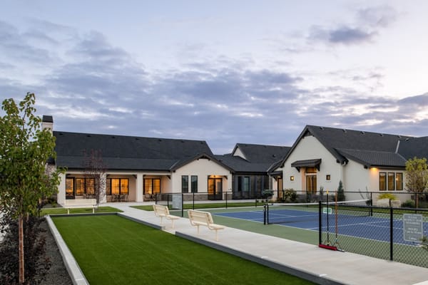 Tennis court with seating and adjacent residential building at Cadence at Century Farm.